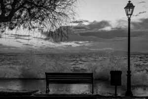 Black and white image of a bench in front of the sea. It represents the theme of the article - the suicide of an atheist - from the Revista Espírita of 1861